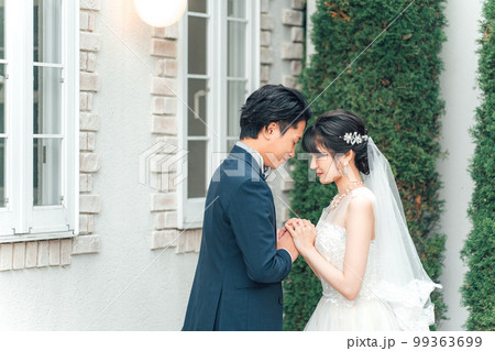結婚式で結婚式場の庭でブーケを持つ新郎新婦(ガーデンウェディング) 結婚式で結婚式場の庭でブーケを持つ新郎新婦(ガーデンウェディング) 99363699