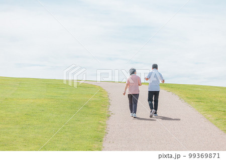 公園でウォーキング・有酸素運動する高齢者夫婦の後ろ姿（シニア・男女） 99369871