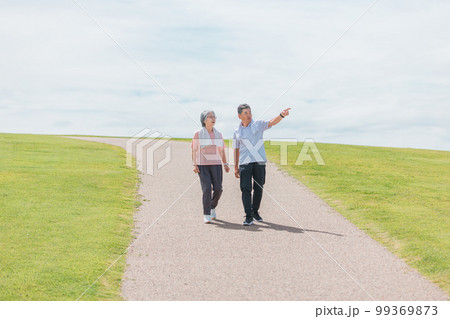 公園でウォーキング・有酸素運動する高齢者夫婦（シニア・男女） 99369873