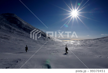 冬の知床半島・二ツ池野営指定地を歩く登山者 99370451