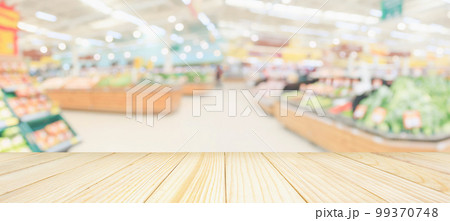 Wood table top with supermarket grocery store blurred defocused background with bokeh light for product display Wood table top with supermarket grocery store blurred defocused background with bokeh light for product display 99370748