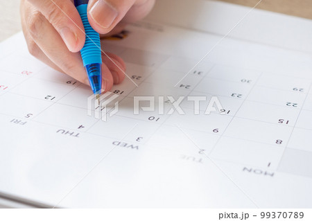Woman hand with pen writing on calendar date business planning appointment meeting concept 99370789