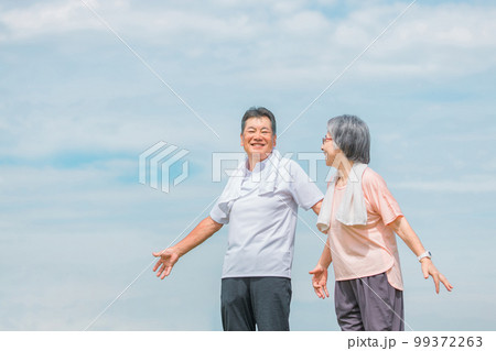 公園でラジオ体操・ストレッチ・深呼吸・柔軟体操をする高齢者夫婦 公園でラジオ体操・ストレッチ・深呼吸・柔軟体操をする高齢者夫婦 99372263