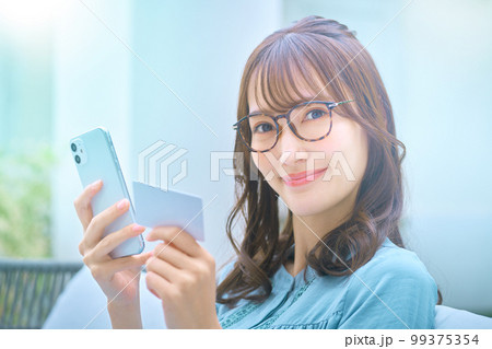 カードを使ってネットショッピングする若い女性 99375354