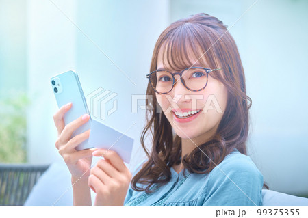 カードを使ってネットショッピングする若い女性 カードを使ってネットショッピングする若い女性 99375355