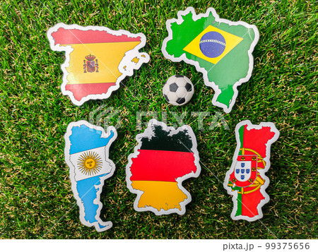 A ball and Portugal,German,Spain,Argentina and brazil flag sticker is on a green field. 99375656
