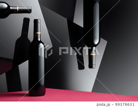 Bottles of red wine with a reflection on the glossy black surface. Bottles of red wine with a reflection on the glossy black surface. 99376631
