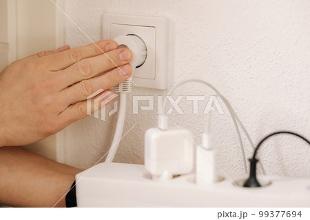 The extension cord filled with chargers is connected to a 220V outlet The extension cord filled with chargers is connected to a 220V outlet 99377694
