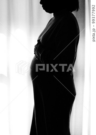 逆光シルエットで佇む妊婦（マタニティフォト） 99377992