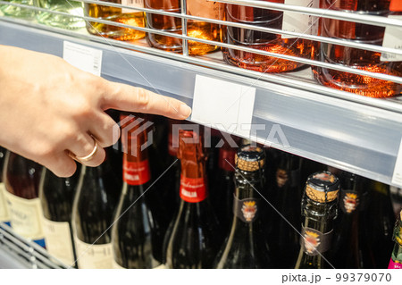 Woman indicates cost of item with finger in grocery store Woman indicates cost of item with finger in grocery store 99379070
