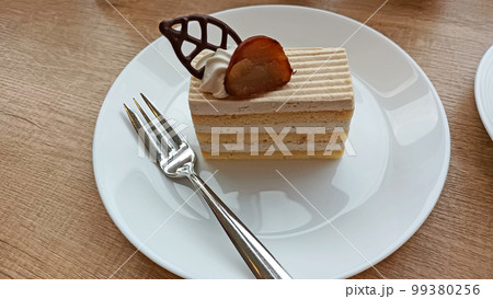 白いお皿に乗った甘いケーキでほっと一息 白いお皿に乗った甘いケーキでほっと一息 99380256