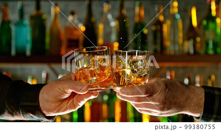 Close-up view of a two whiskey shots in hands. 99380755