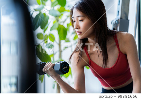 スポーツジムでトレーニングする若い女性 スポーツジムでトレーニングする若い女性 99381666