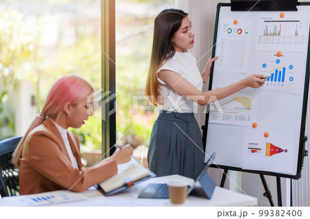 Concept of business investment or working woman, Businesswoman wearing a suit discussing or working on analysis of business investment documents and using computer tablet to analytic business data. Concept of business investment or working woman, Businesswoman wearing a suit discussing or working on analysis of business investment documents and using computer tablet to analytic business data. 99382400