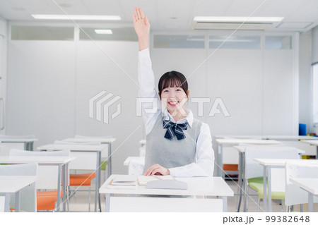 授業中に手を挙げる女子高生 99382648