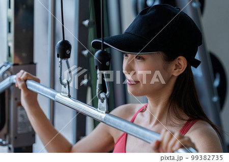 スポーツジムでトレーニングする若い女性 スポーツジムでトレーニングする若い女性 99382735
