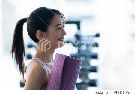 スポーツジムでトレーニングする若い女性 99383056