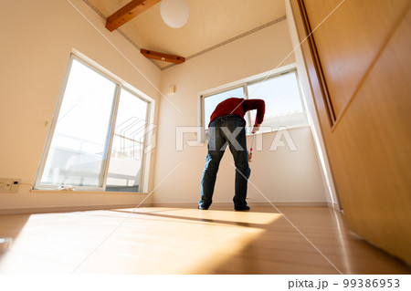 部屋のワックスがけをする男性 99386953