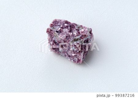 Mineral stone lepidolite. Macro shooting of natural gemstone. The raw mineral, white backround 99387216