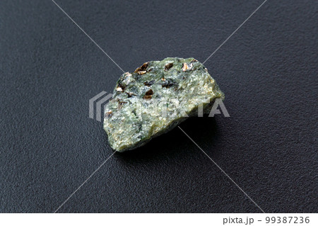 Rock with peridot olivine mineral, black background. Close-up Rock with peridot olivine mineral, black background. Close-up 99387236