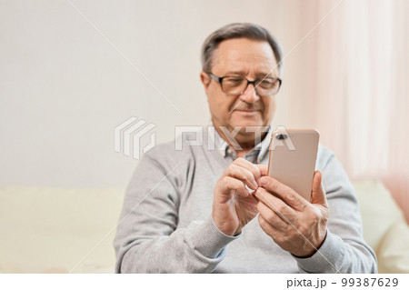 Portrait of smiling mature man using mobile phone 99387629