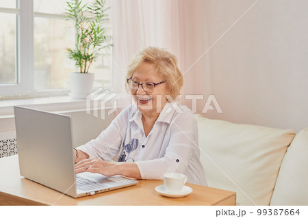 Happy mature middle aged elderly woman reading good news looking at laptop 99387664