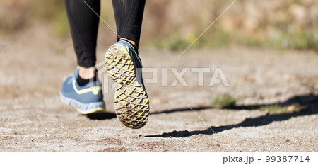 Trail running athlete exercising for fitness and health outdoors on mountain pathway, closeup of running shoes in action 99387714