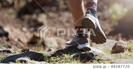 Trail running athlete exercising for fitness and health outdoors on mountain pathway, closeup of running shoes in action 99387720
