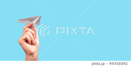 Banner with female hand throwing origami plane on turquoise background. Handmade paper aircraft. Freedom, childhood, fun concept. Place for text Banner with female hand throwing origami plane on turquoise background. Handmade paper aircraft. Freedom, childhood, fun concept. Place for text 99388892