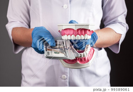 Expensive dentistry concept. Dentist with dollars money for teeth health Expensive dentistry concept. Dentist with dollars money for teeth health 99389061
