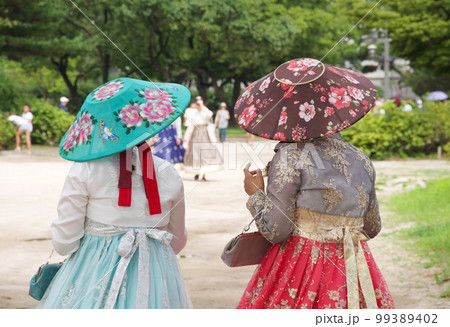 韓国ソウルの観光名所である景福宮をレンタルのチマチョゴリ(韓服)を着用して歩く若い女性。 韓国ソウルの観光名所である景福宮をレンタルのチマチョゴリ(韓服)を着用して歩く若い女性。 99389402