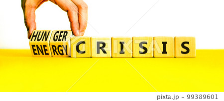 Energy or hunger crisis symbol. Concept word Energy crisis and hunger crisis on wooden cubes. Beautiful white background. Businessman hand. Business Energy or hunger crisis concept. Copy space. 99389601