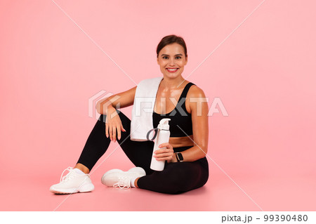 Smiling Sporty Woman With Water Bottle In Hand Relaxing After Training Smiling Sporty Woman With Water Bottle In Hand Relaxing After Training 99390480
