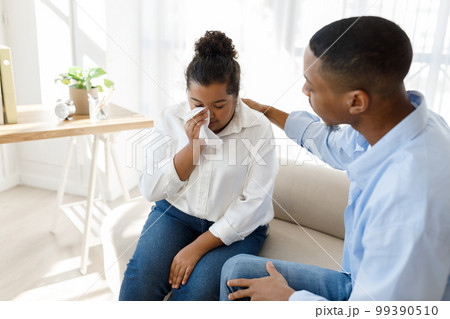 African man psychologist supporting crying hispanic woman African man psychologist supporting crying hispanic woman 99390510