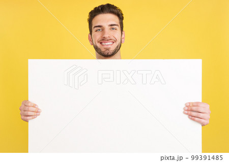 Happy caucasian man smiling while holding a blank panel 99391485
