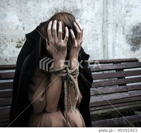 The bound prisoner sit on the bench 99391925