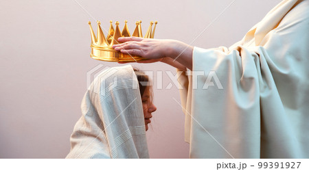 Hands placing a crown on a woman's head Hands placing a crown on a woman's head 99391927