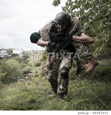 The commander carries a wounded soldier The commander carries a wounded soldier 99391933