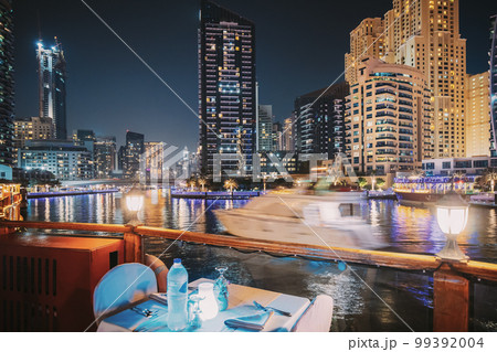 Night View Of City Skyline From Tourist Boat, Sightseeing Boat Sailing On Dubai Marina. Night Walk Of Dubai Marina Is District in Dubai, United Arab Emirates Night View Of City Skyline From Tourist Boat, Sightseeing Boat Sailing On Dubai Marina. Night Walk Of Dubai Marina Is District in Dubai, United Arab Emirates 99392004