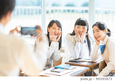 教室でスマホで写真を撮る女子高生 99393873