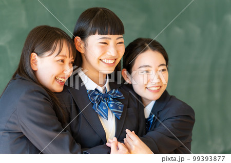 黒板の前に立つ制服姿の女子高生 99393877