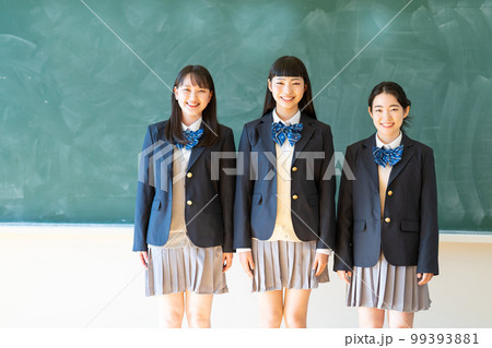 黒板の前に立つ制服姿の女子高生 99393881