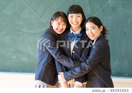 黒板の前に立つ制服姿の女子高生 99393883