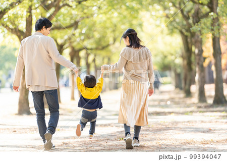 手をつないで歩く親子の後ろ姿 手をつないで歩く親子の後ろ姿 99394047
