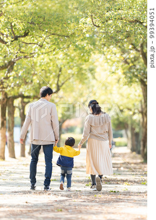 手をつないで歩く親子の後ろ姿 99394051