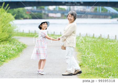 手をつないで歩く女の子とお婆ちゃん 99395318