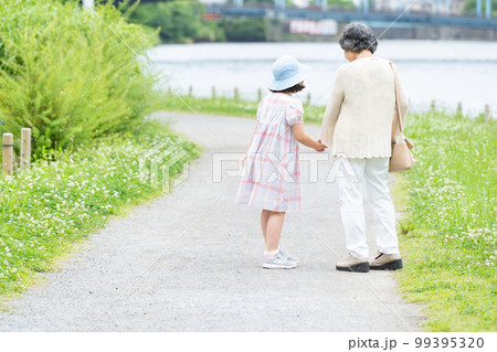 手をつないで歩く女の子とお婆ちゃん 99395320