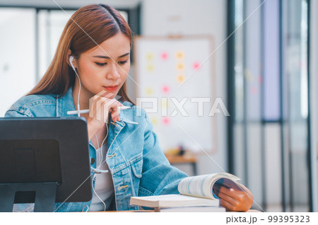 young student wearing small talk studies online, distance learning, and keeps up to date on the global coronavirus pandemic 99395323