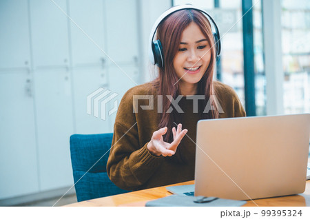 young student wearing headphones studies online, distance learning, and keeps up to date on the global coronavirus pandemic.. 99395324