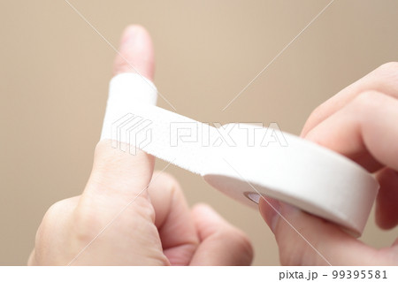 指にテーピングを巻く男性 指にテーピングを巻く男性 99395581